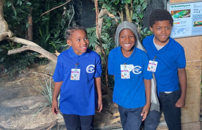  Three 1st graders posing at the zoo learning about all the animals. 